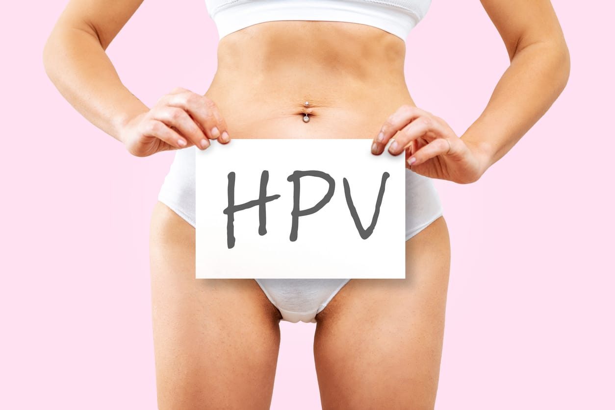 Donna che tiene un cartello con scritto HPV